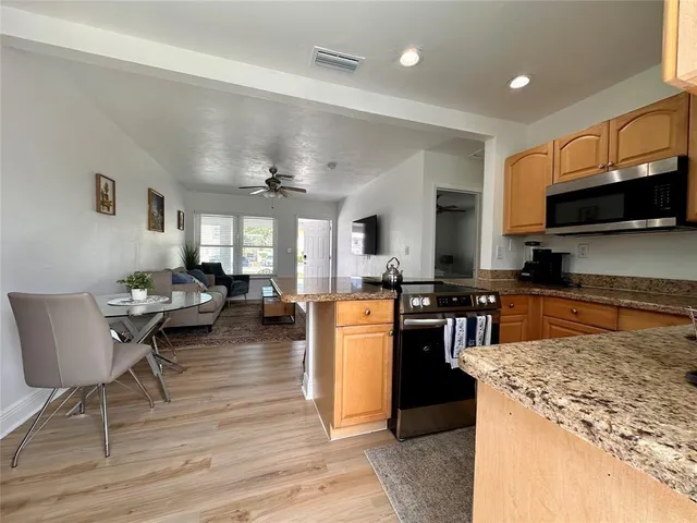 a kitchen with stainless steel appliances granite countertop a refrigerator stove microwave and cabinets