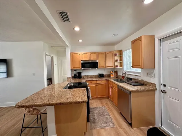 a kitchen with stainless steel appliances granite countertop a sink stove and refrigerator