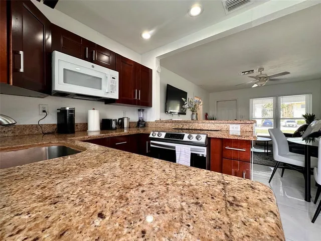 a large kitchen with stainless steel appliances granite countertop a stove granite counter tops and white cabinets