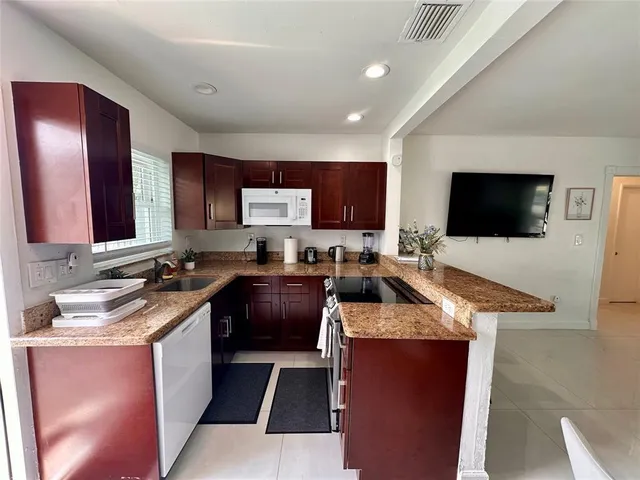a kitchen with stainless steel appliances granite countertop a sink stove and microwave