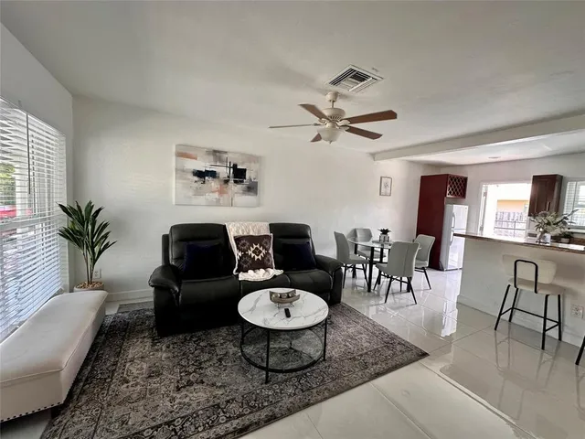 a living room with furniture a dining table and a potted plant