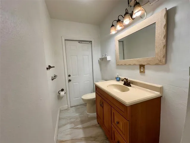 a bathroom with a sink a toilet and mirror
