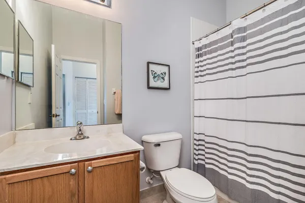 a bathroom with a granite countertop toilet sink and mirror