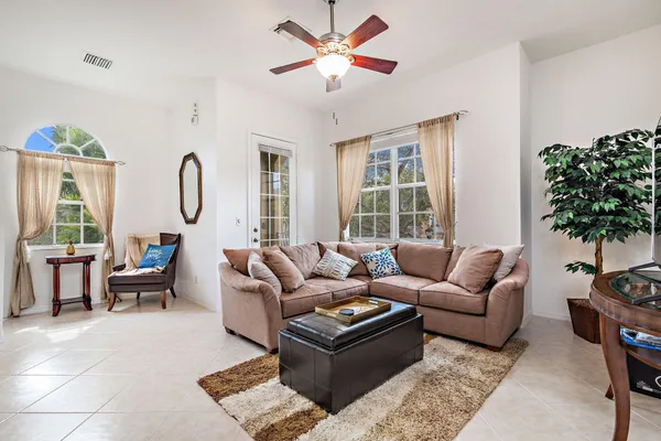 a living room with furniture a chandelier and a window