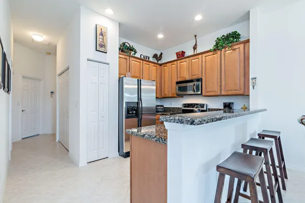 a kitchen with stainless steel appliances granite countertop a refrigerator a stove top oven a sink and dishwasher