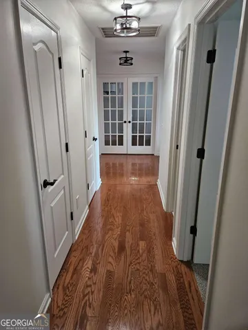 a view of a hallway with wooden floor and windows