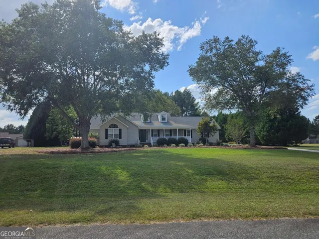 a front view of a house with a yard and trees