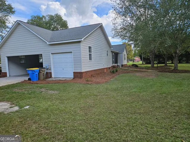 a backyard of a house with table and chairs