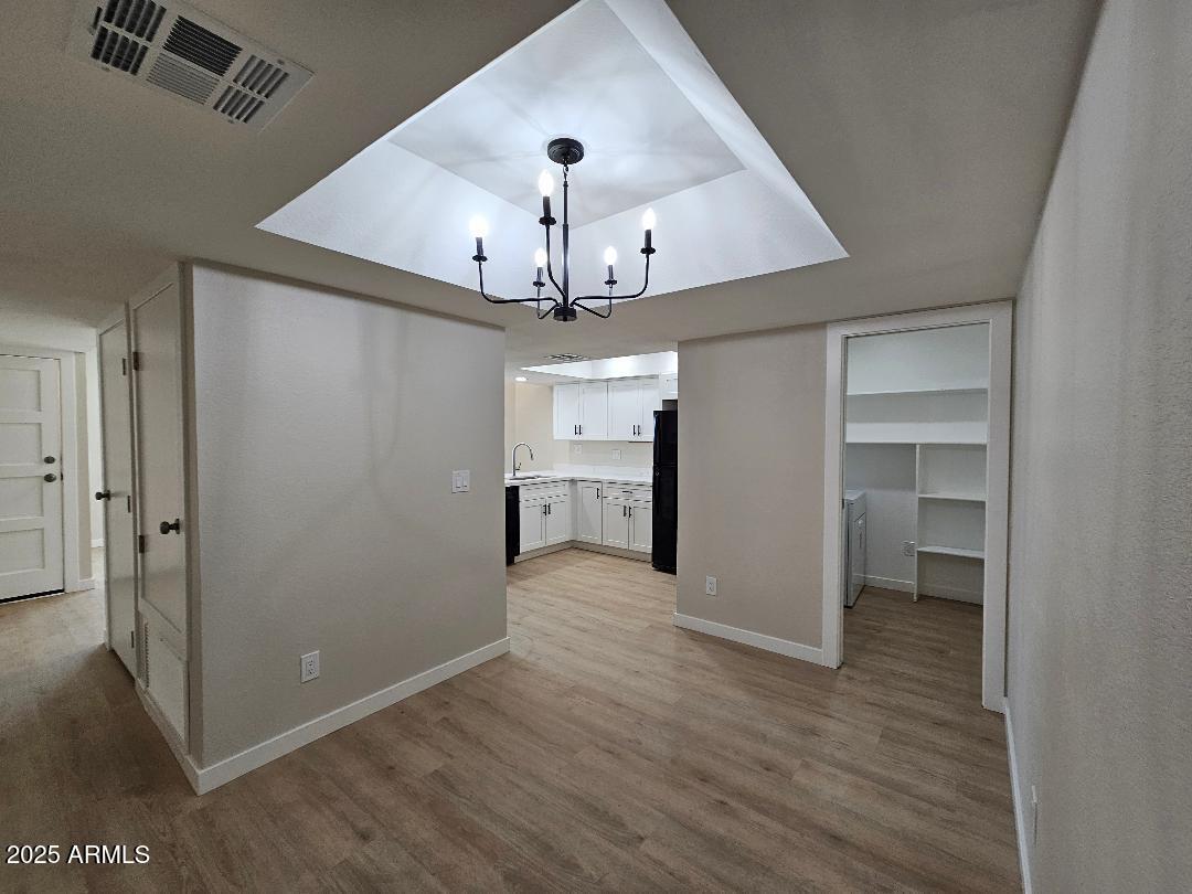 2020 West Union Hills Drive, Unit 116 Phoenix, AZ 85027 - Photo 11 of 28 an empty room with wooden floor chandelier and entryway