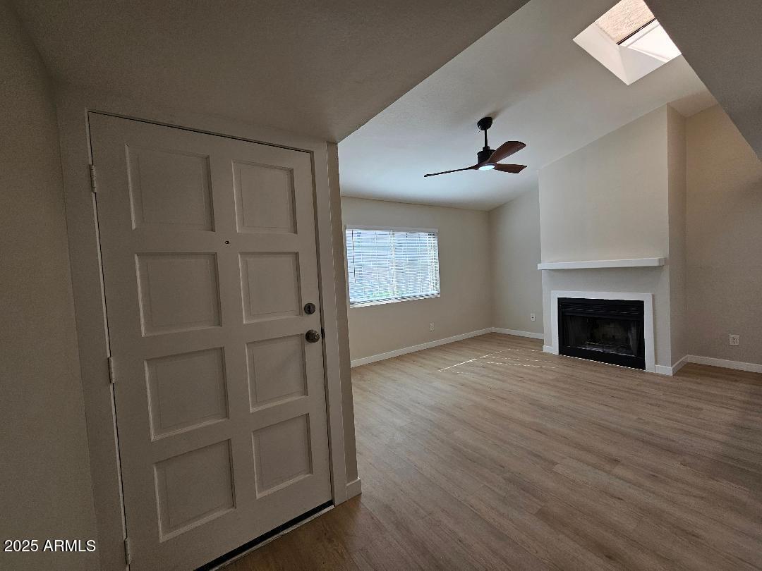 2020 West Union Hills Drive, Unit 116 Phoenix, AZ 85027 - Photo 2 of 28 an empty room with windows a fireplace and a chandelier fan