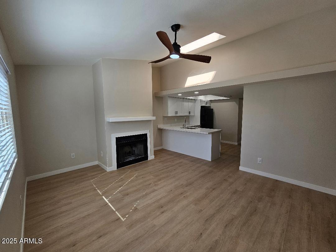 2020 West Union Hills Drive, Unit 116 Phoenix, AZ 85027 - Photo 4 of 28 a view of a livingroom with a fireplace a ceiling fan and wooden floor