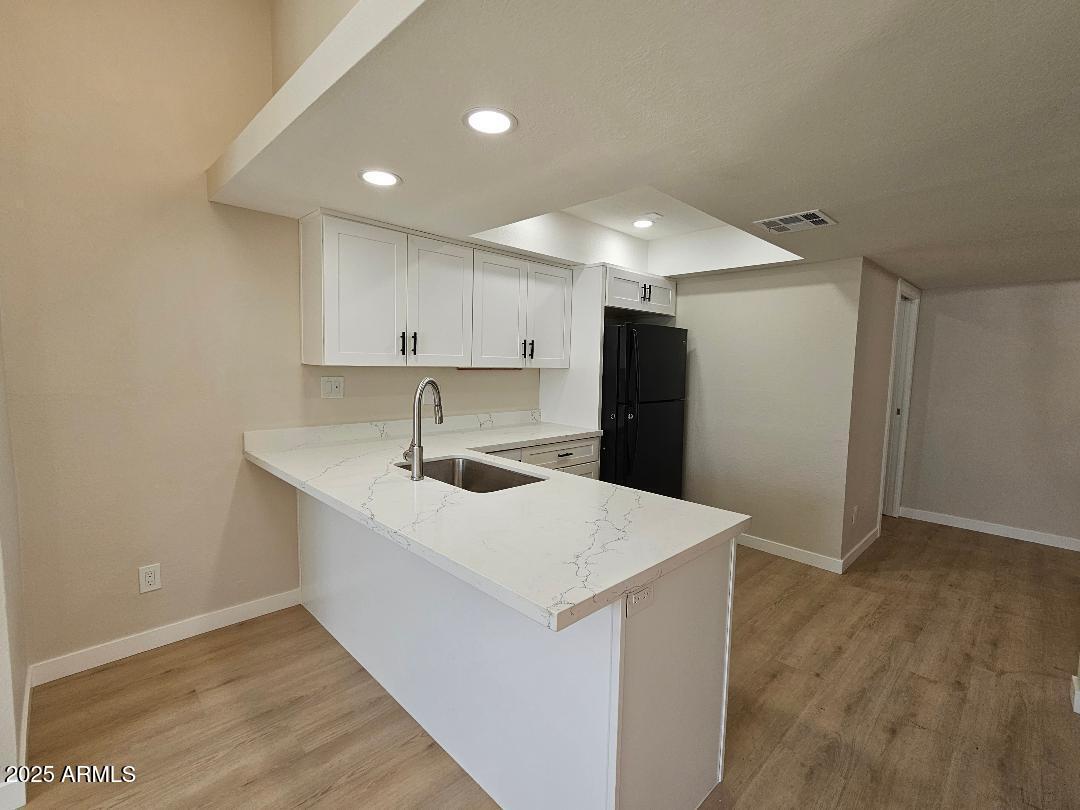 2020 West Union Hills Drive, Unit 116 Phoenix, AZ 85027 - Photo 6 of 28 a kitchen with a sink a refrigerator and white cabinets