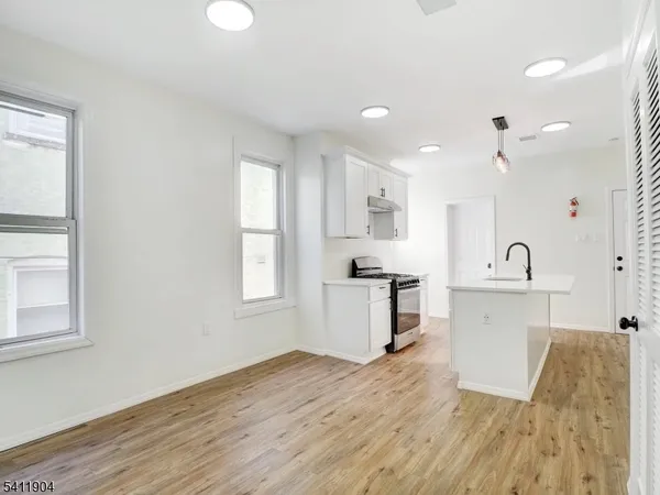 a large white kitchen with wooden floors and white walls
