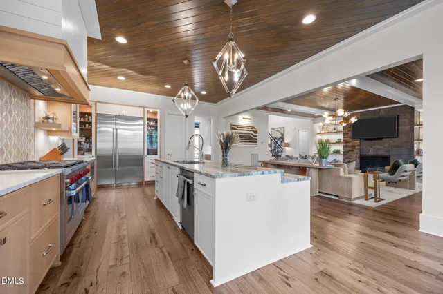 a large kitchen with kitchen island a large counter space a sink appliances and cabinets