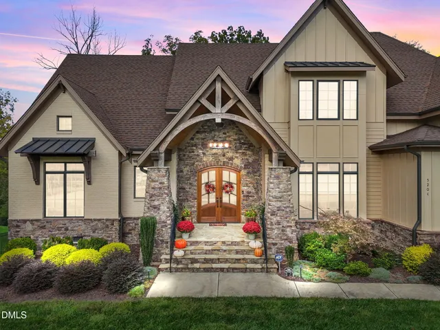 a front view of a house with a yard and trees