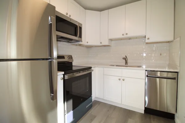 a kitchen with stainless steel appliances white cabinets and a granite counter tops