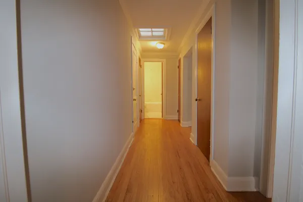 a view of a hallway with wooden floor