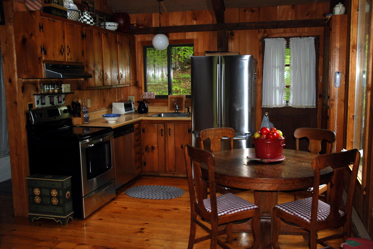 221 Judd Road Otis, MA 01253 - Photo 6 of 23 a kitchen with stainless steel appliances granite countertop a stove a refrigerator a dining table and chairs