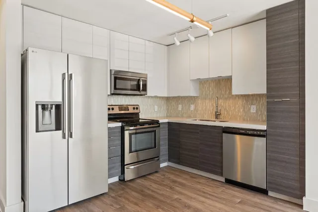 a kitchen with granite countertop a refrigerator stove and sink