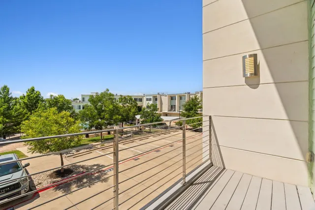 a view of a balcony with wooden floor and fence and a bench