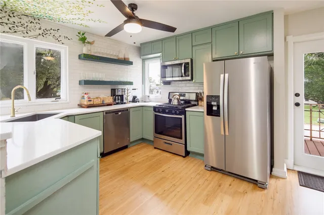 a kitchen with stainless steel appliances granite countertop a refrigerator a sink dishwasher a stove and a refrigerator