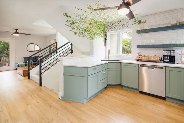 a kitchen with a sink a stove cabinets and wooden floor