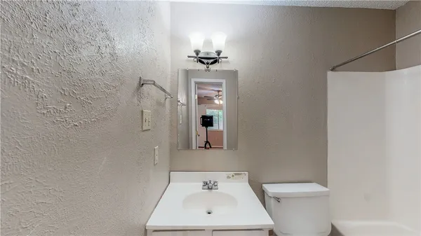 a bathroom with a sink a toilet and mirror
