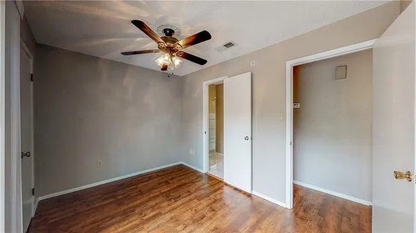 a view of a room with wooden floor and ceiling fan