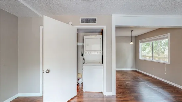 a view of a hallway with wooden floor and a bathroom