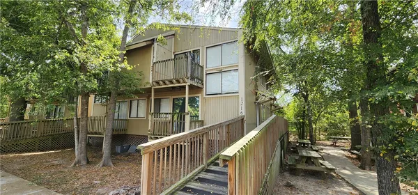 a view of a house with a tree and wooden fence