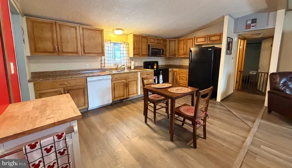 a kitchen with granite countertop wooden floors furniture and stainless steel appliances