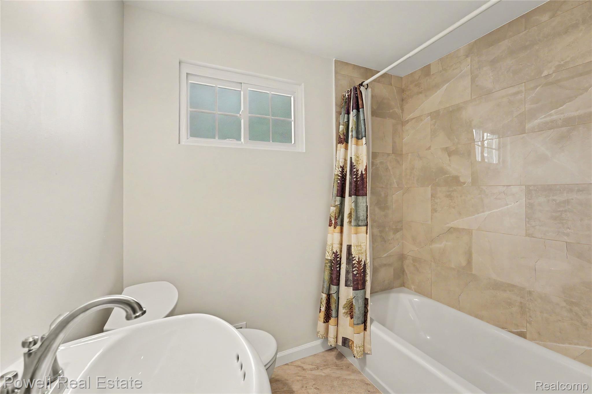 18166 Davidson Road Fraser, MI 48026 - Photo 14 of 27 Bathroom featuring a bathtub with a polished tile surround, a new pedestal sink, toilet, and fresh paint