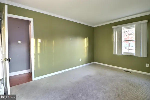 a view of an empty room with window and closet area