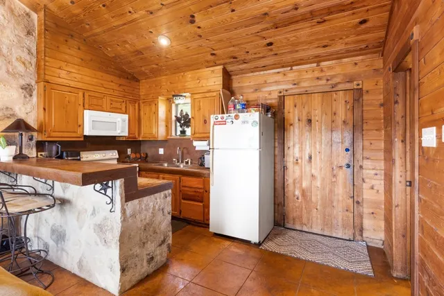 a view of a refrigerator in kitchen and utility room
