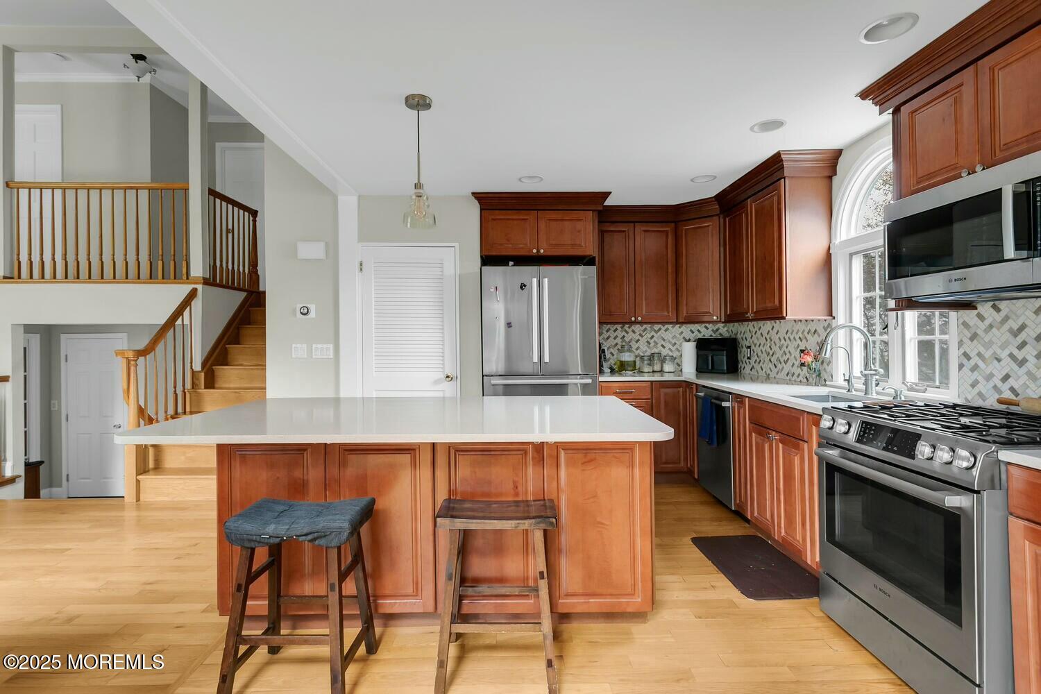 21 Judith Road Little Silver, NJ 07739 - Photo 9 of 48 a kitchen with stainless steel appliances granite countertop a stove top oven a sink a dining table and chairs with wooden floor