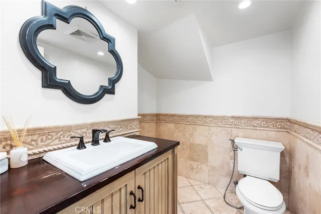 a bathroom with a sink a toilet and a mirror