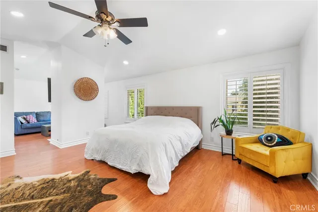 a spacious bedroom with a bed window and couch