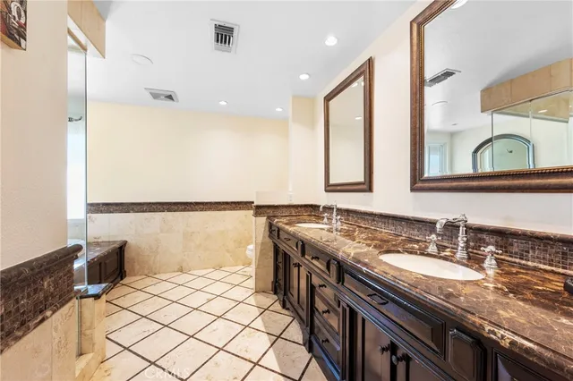 a bathroom with a granite countertop sink a mirror and a shower