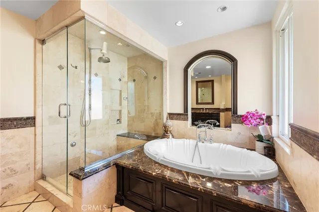 a bathroom with a granite countertop sink a mirror and a shower