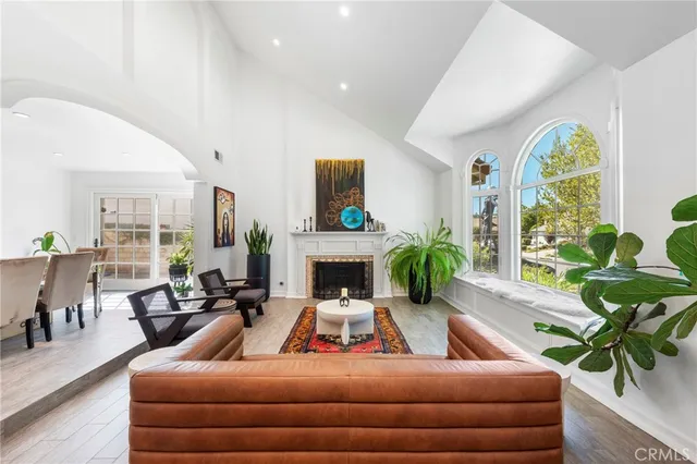 a living room with furniture fireplace and potted plants