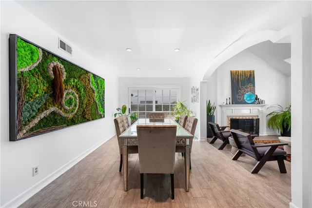 a dining room with furniture floor to ceiling window and wooden floor