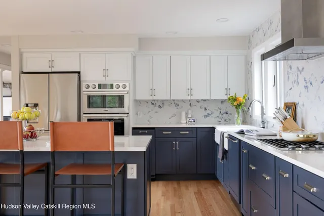 a kitchen with stainless steel appliances granite countertop a stove a sink dishwasher and a refrigerator with wooden cabinets