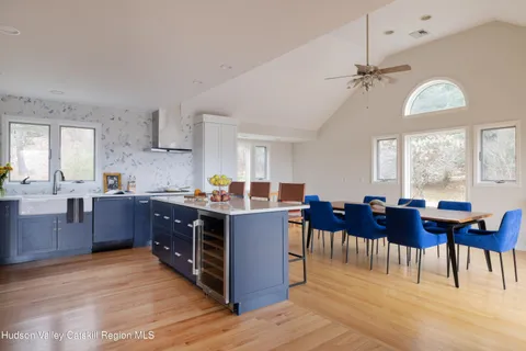 a kitchen with a dining table chairs and wooden floor