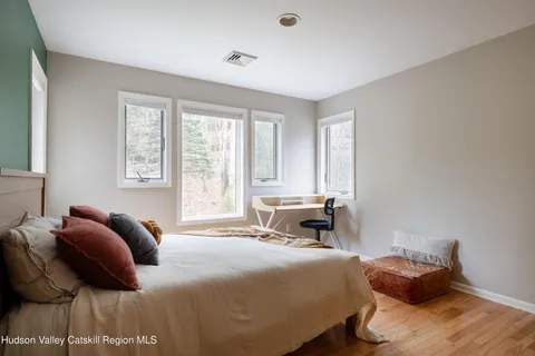 a bedroom with a bed and wooden floor