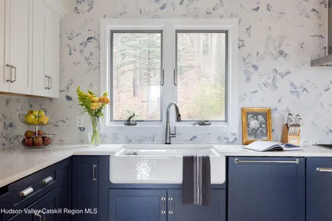 a kitchen with stainless steel appliances a sink a window and cabinets