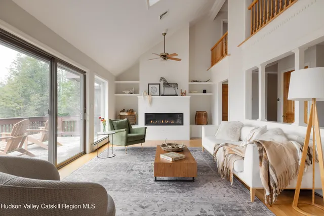 a living room with furniture fireplace and a large window