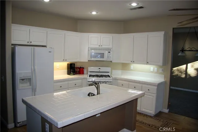 a kitchen with kitchen island white cabinets stainless steel appliances and wooden floor
