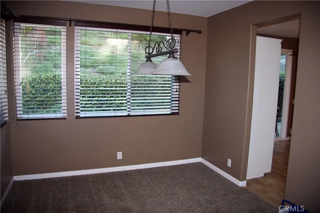 a view of an empty room with a window and a ceiling fan