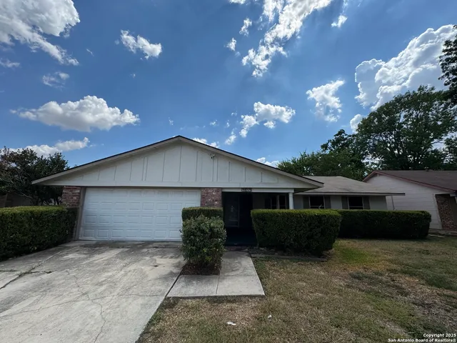 a front view of a house with yard and green space