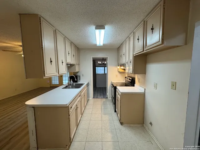 a kitchen with stainless steel appliances granite countertop a sink a stove and a refrigerator